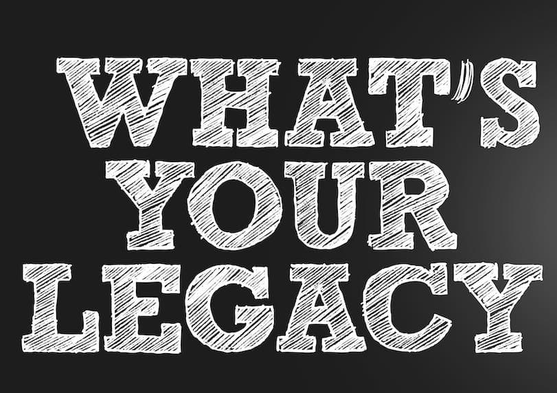 A black and white image with the text “What’s your legacy” in a hand-drawn style font. The text is in all caps and is in a white color. The background is black.