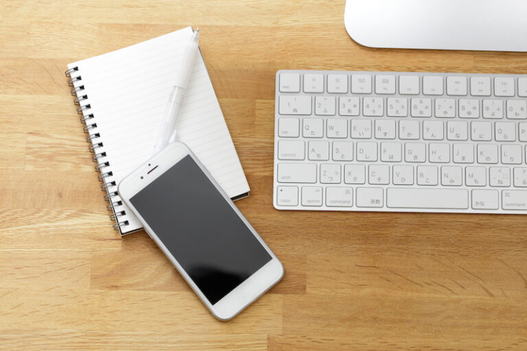 Smartphone, tablet and keyboard on a wooden desk Smartphone, tablet and keyboard on a wooden desk